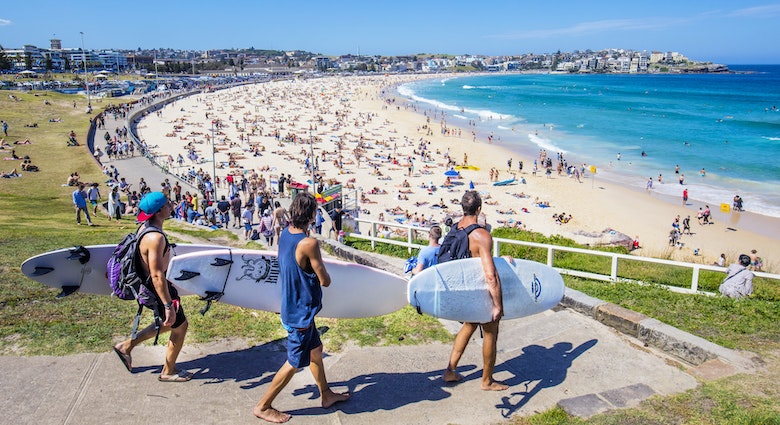 Sydney, Australia - November 19, 2015: Three surfers heading to the Bondi Beach Bondi beach with their surf boards on a sunny day.