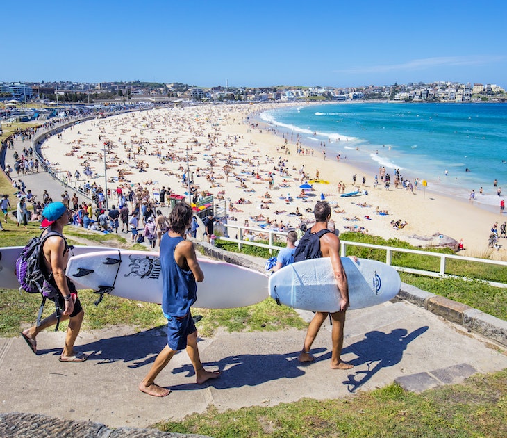 Sydney, Australia - November 19, 2015: Three surfers heading to the Bondi Beach Bondi beach with their surf boards on a sunny day.