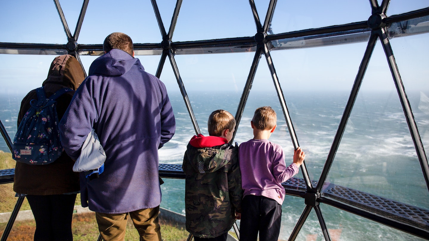 A family looks out of the Mull of Galloway's lighthouse © Emily Macinnes/Lonely Planet