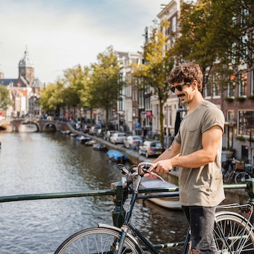 Man riding bike through Amsterdam.